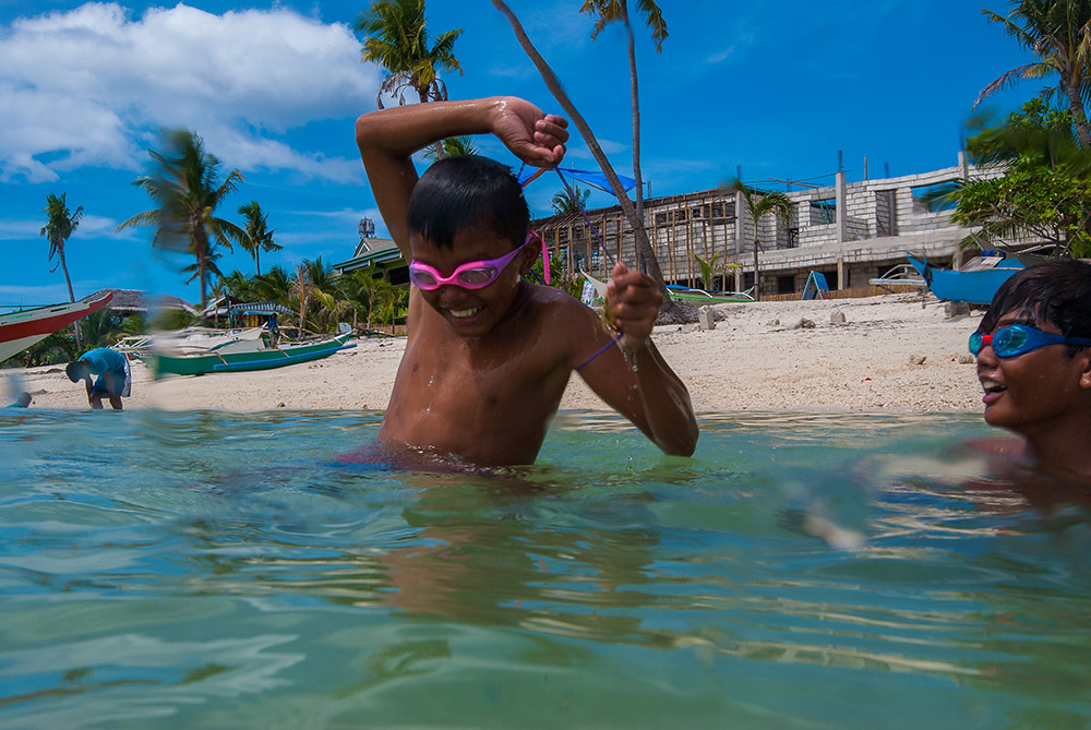 ragazzo filippino immersioni snorkeling a cebu spiaggia bianca